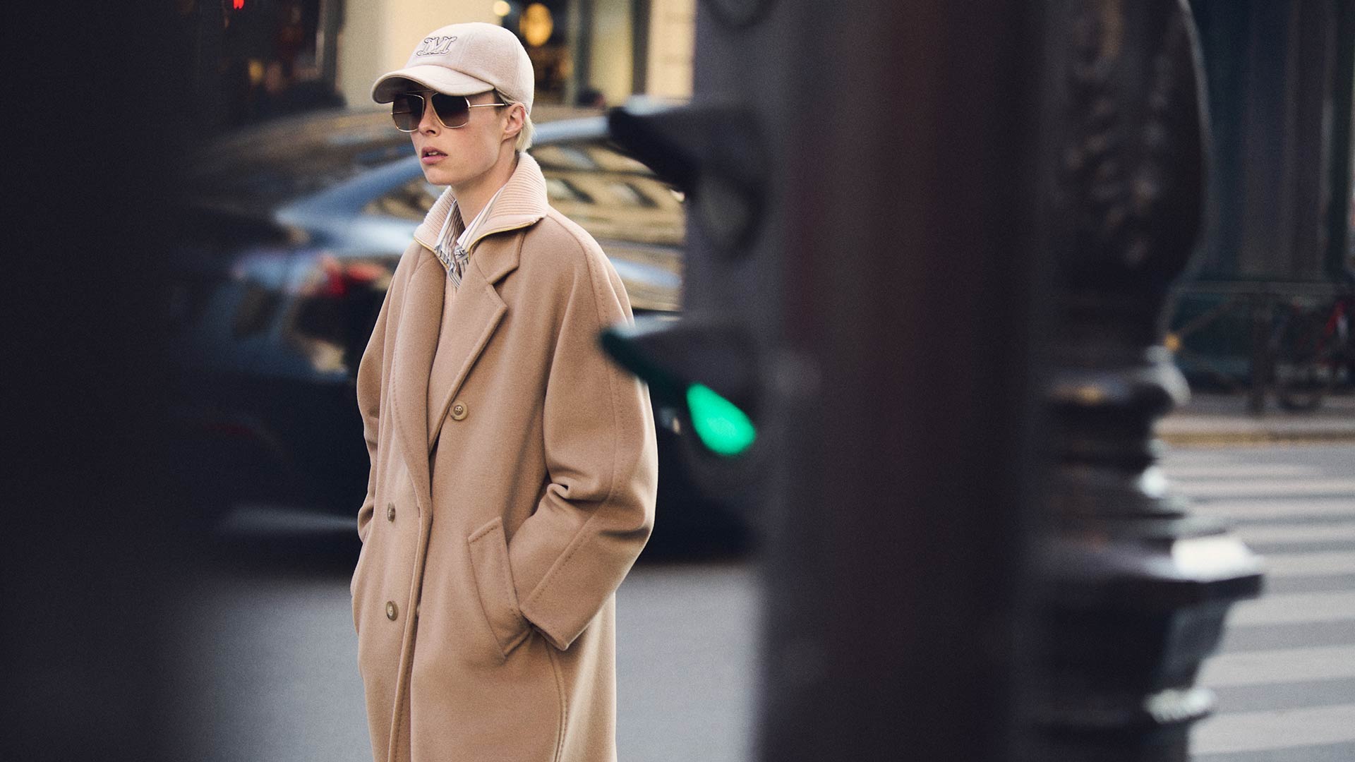 Modelo con el icónico abrigo largo Max Mara 101801 color camel, combinado con gorro y gafas oscuras. 