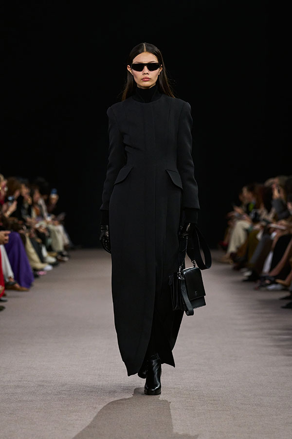 Desfile Max Mara otoño-invierno 2025 - Look color negro con gafas de sol tipo máscara, bolso bandolera de piel y botines.