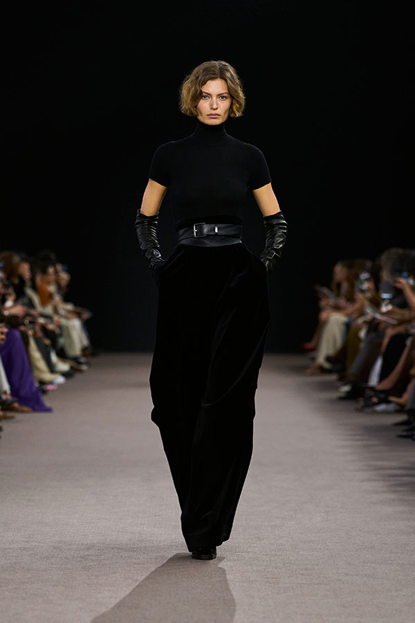 Desfile Max Mara otoño-invierno 2025 - Look negro con jersey, guantes largos de napa y pantalón de terciopelo satinado.