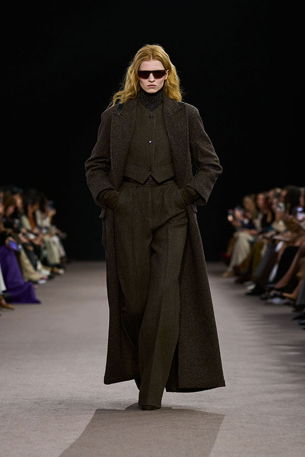 Desfile Max Mara otoño-invierno 2025 - Look marrón con gafas de sol, chaleco, guantes largos y pantalón amplio.