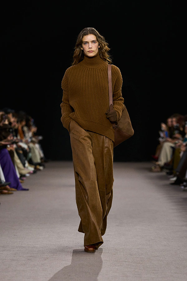 Desfile Max Mara otoño-invierno 2025 - Look color cuero con jersey de cuello alto de corte peplo y pantalón amplio.