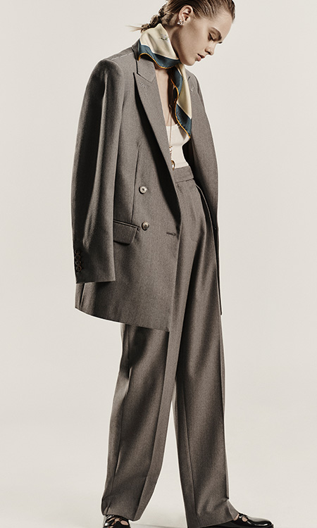 Modelo con look gris con blazer de grain de poudre de lana Max Mara Sartoriale y pantalón de cintura alta.