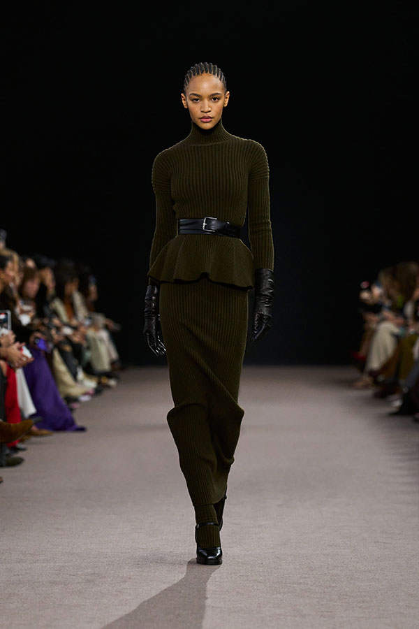 Desfile Max Mara otoño-invierno 2025 - Look verde musgo con jersey peplo, cinturón, guantes, falda de tubo y merceditas.