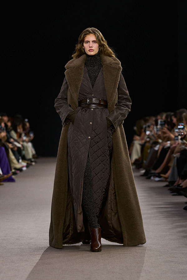 Desfile Max Mara otoño-invierno 2025 - Look marrón con abrigo largo sin mangas de Teddy, abrigo acolchado y botines.